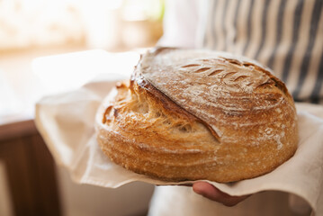 Just baked bread in hands of a woman. Baking bread at home concept