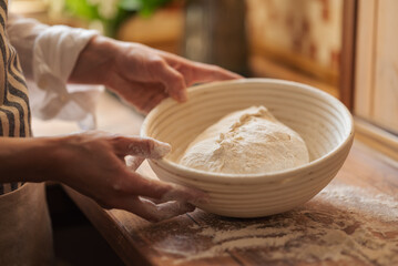 Dough for bread resting in wooden plate. Baking bread at home concept