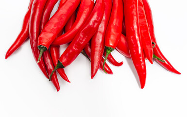 Vertical bunch of oblong red chili peppers. White background isolated. Part of pepper in photo.