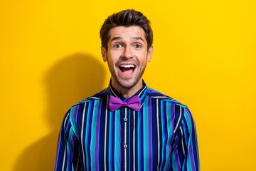 Photo of impressed man with stubble dressed striped shirt tie bow astonished staring at sale isolated on vivid yellow color background