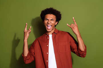 Photo portrait of attractive young man show horns gesture rock roll music wear trendy brown clothes isolated on khaki color background