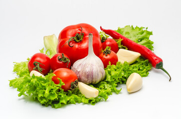 Tomato, pepper, garlic, green salad leaves. Vegan diet food, creative composition isolated on white