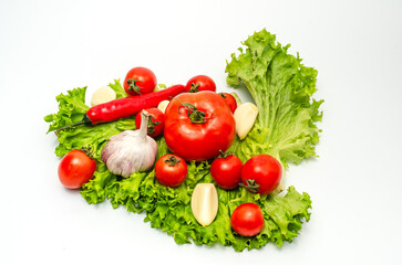 Mix of fresh vegetables - pepper,garlic, tomatoes and green salad leaves. White background, isolated..
