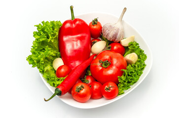 Delicious vegetable salad in bowl with water drops. Tomatoes, lettuce, garlic, chili, sweet pepper.