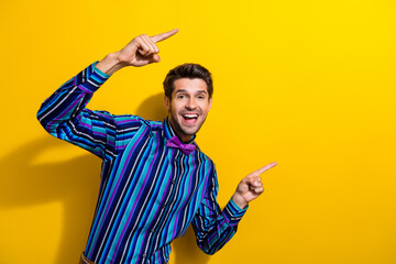 Photo of optimistic guy with stubble dressed striped shirt indicating at proposition empty space...