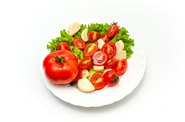 White plate of salad with vegetables on white background. Top view. Tomato, pepper, salad, garlic.