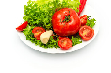 Delicious vegetable salad in a bowl on a white background. Chopped tomatoes, lettuce, garlic.