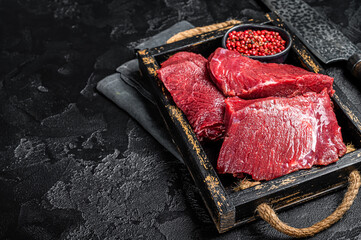 Uncooked Raw Venison dear meat, game meat. Black background. Top view. Copy space