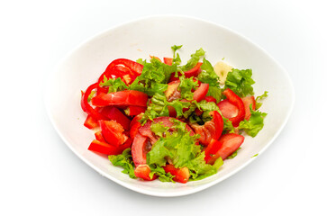 White plate of salad with vegetables isolated on white background. Front view. Tomato, pepper, salad.