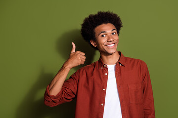 Fototapeta na wymiar Portrait of pleasant satisfied guy with chevelure hairdo wear stylish shirt showing thumb up good work isolated on green color background