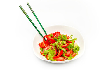 White plate of salad with vegetables isolated on white background. Wooden chopsticks for food.