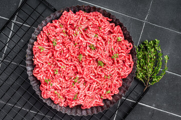 Raw Minced beef and pork meat for a burger patty or meatballs. Black background. Top view