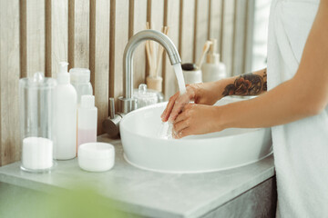 Woman washing her hands in sink in modern stylish bathroom, modern interior, closeup