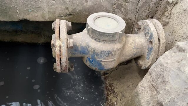 Dirty waste water coming out from pipe on Wastewater Treatment Procedure (WWTP). Pouring water produce foam on the pond. Chemical waste water from industrial process.