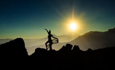silhouette of a dancer on a mountain top