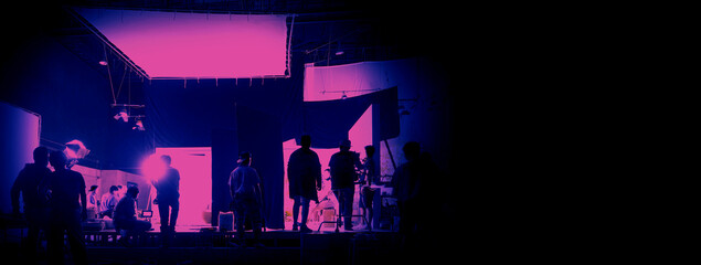 Silhouette of people working in big production studio for shooting or recording movie video by...