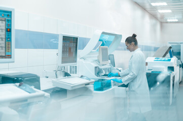 A laboratory technician in a lab coat performs a series of tests on a chemical analyzer in a bio laboratory. impersonal unrecognizable laboratory
blurred fuzzy background shot through glass with space