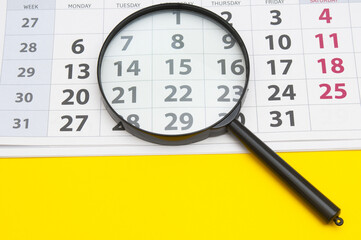  Desk calendar for month with magnifying lens  on yellow background