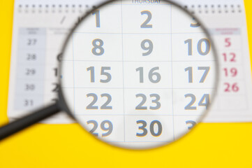  Desk calendar for month with magnifying lens  on yellow background