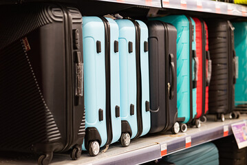 A customer chooses a suitcase for luggage in a department store. Buying small luggage for a...
