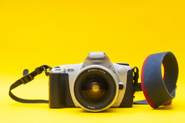 Old-fashioned film camera close up on a yellow background
