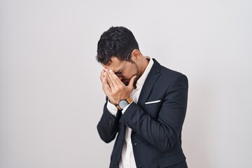 Handsome business hispanic man standing over white background with sad expression covering face...