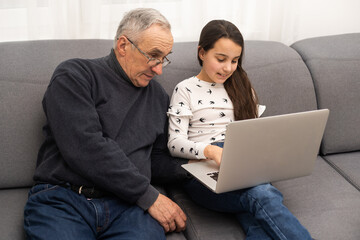 grandfather and granddaughter with laptop