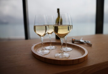 Lot of glasses with white wine and bottle standing on table in restaurant closeup. Celebration for birthday with alcohol concept