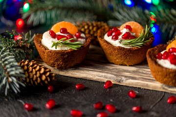 Fototapeta na wymiar Christmas nut tartlets. Delicious, beautiful cupcakes are decorated with Christmas garlands and Christmas tree branches. Selective focus