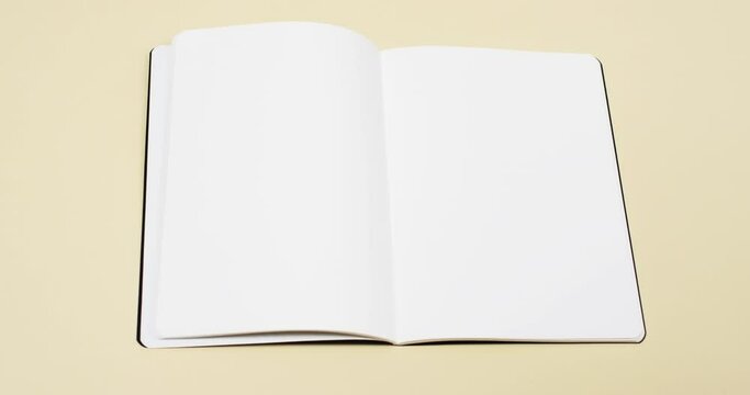 Video of book with white blank pages and copy space on yellow background