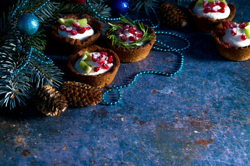 Christmas nut tartlets. Delicious, beautiful cupcakes are decorated with Christmas garlands and Christmas tree branches. Selective focus. Copy space