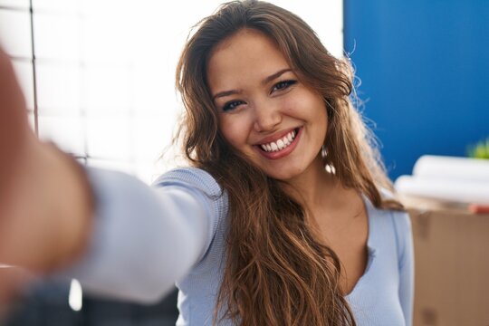 Young beautiful hispanic woman smiling confident make selfie by camera at new home