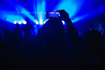 Many hands with smartphone on to record or take photos during live concert, rock concert, music...