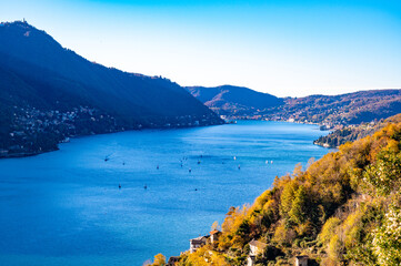 Panorama of Lake Como and the shore of Como, with villages and mountains above.
