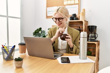 Young blonde woman business worker using laptop drinking mate infusion at office