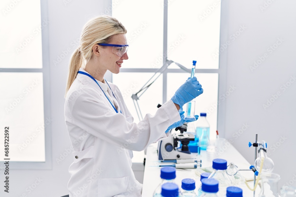 Sticker young blonde woman scientist analysing test tubes at laboratory