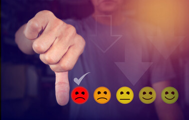 Customer service concept and dissatisfaction Business people touching virtual screen on frown icon who are angry in order to cause dissatisfaction with the service, rating, and dissatisfaction