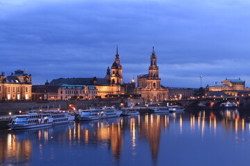 Dresden skyline during the blue hour, showing building reflections on the Elbe river and boats nearby