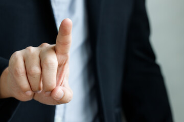 Obraz premium Pointing finger close-up shot of a man in a black business suit with copyspace and background