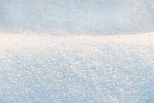Winter background with snow-covered wavy uneven ground surface, snow texture