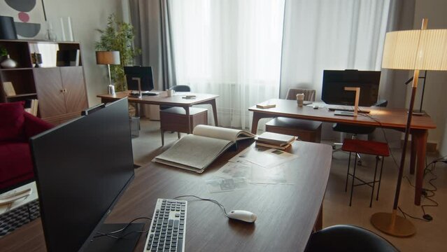 Interior of designers working place with personal display, computer and desk in spacious office for three people