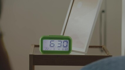 Woman waking up in the morning and stopping alarm clock