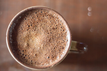 Large cup of coffee with cappuccino on a wooden table, image top view