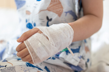 Close up child hand with saline IV solution in hospital