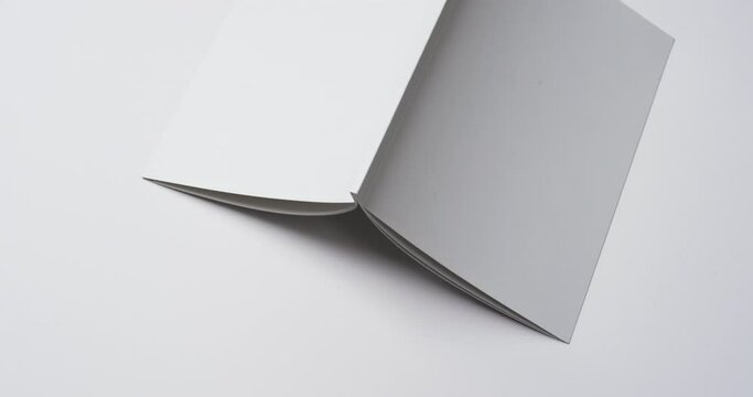 Video of book with white blank cover pages and copy space on white background