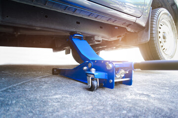 Lifting a pickup truck with a hydraulic floor jack for servicing and maintenance in auto repair...