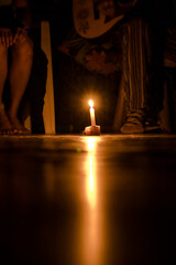 Sao Paulo, SP, Brazil - February 18 2023: White candle lit on the floor with reflected flame details.