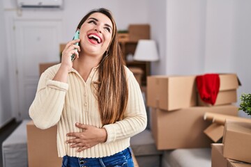 Young beautiful hispanic woman smiling confident talking on smartphone at new home