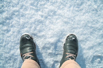 Top view. Feet in winter boots on fresh white snow. Winter Concept