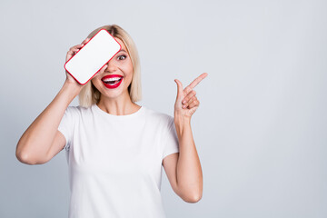 Photo of impressed woman dressed white t-shirt cover eye with smartphone directing at offer empty...